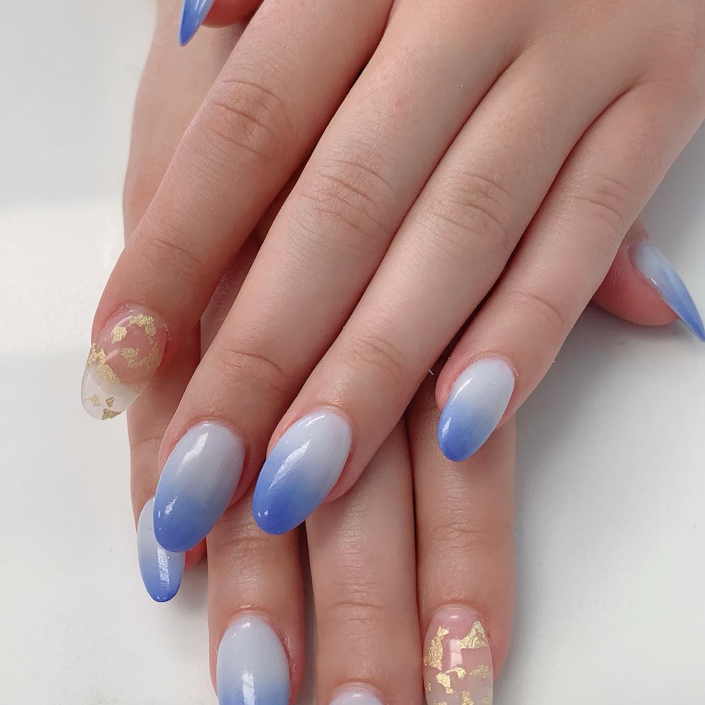Blue ombre nails with gold foil accents